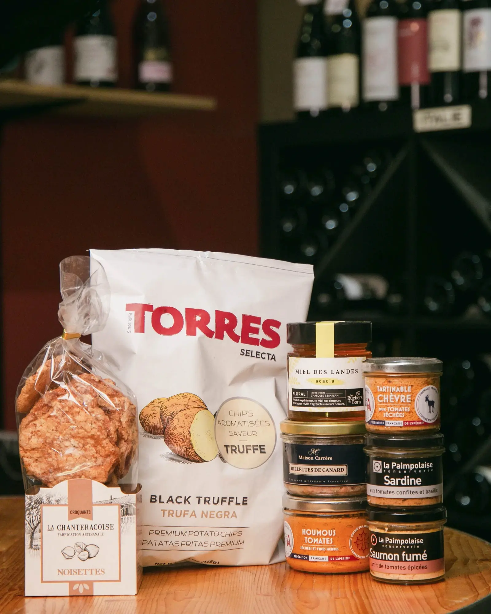 Épicerie fine sur le comptoir de la cave : chips, rillettes et conserves.